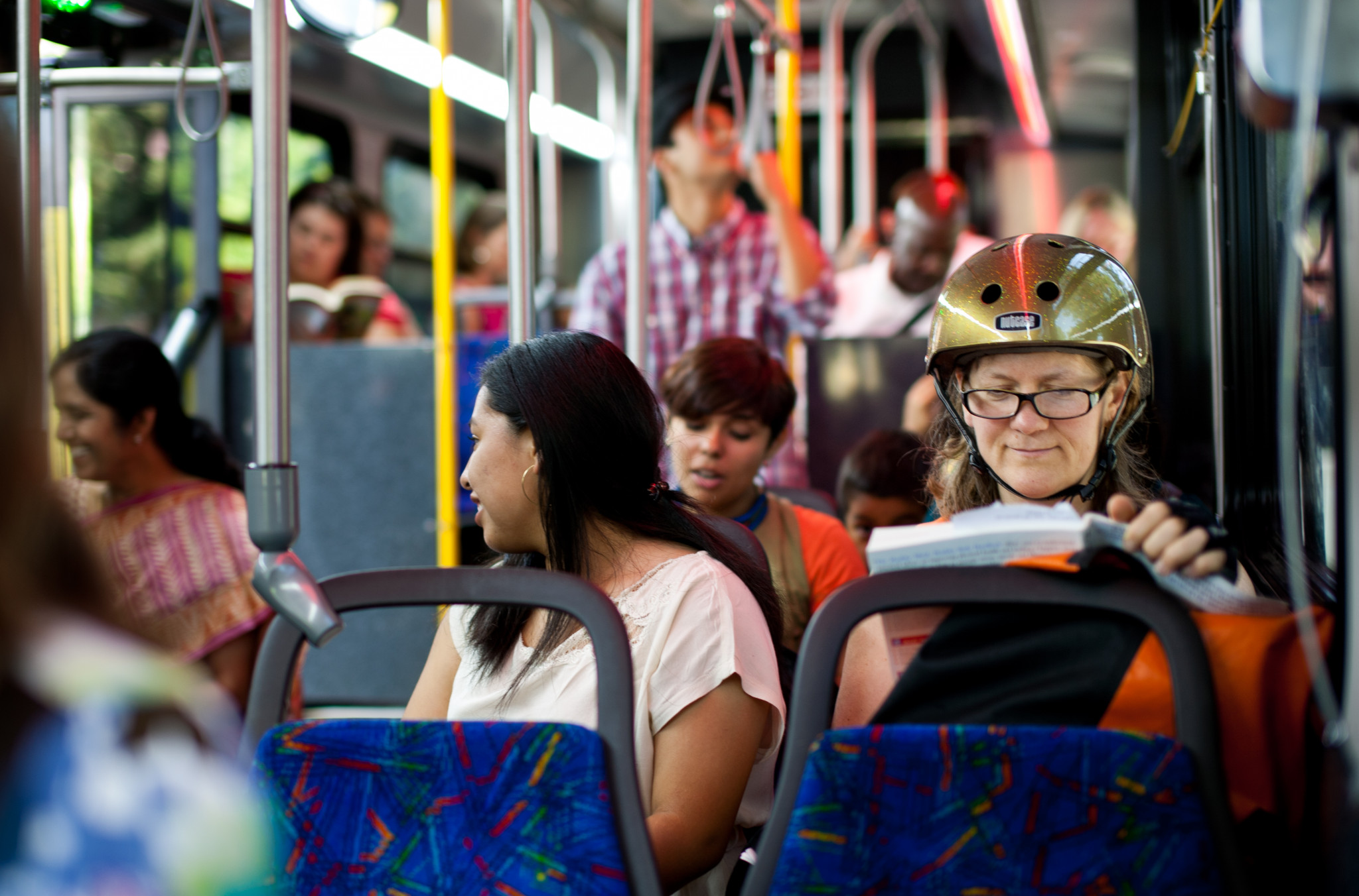 A diverse group of passengers commute together on a city bus.